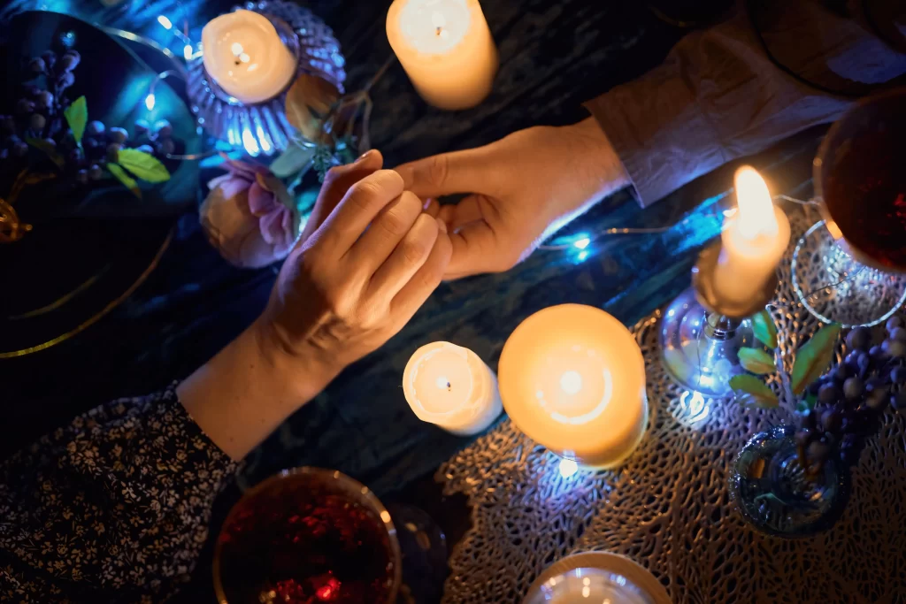 Top view of Couple holding Hands in the table with candle light.