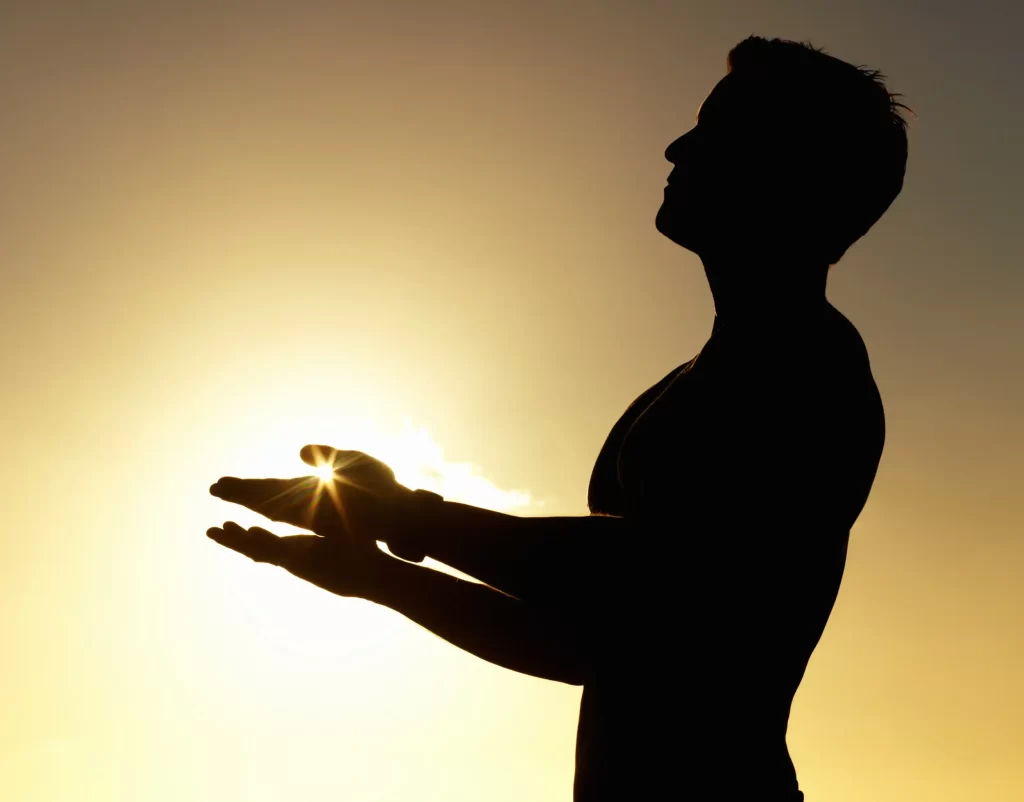 A silhouette of a guy praising the sun.