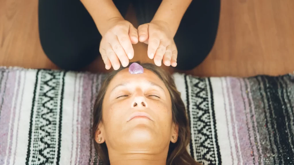 A therapist giving a reiki treatment to woman.